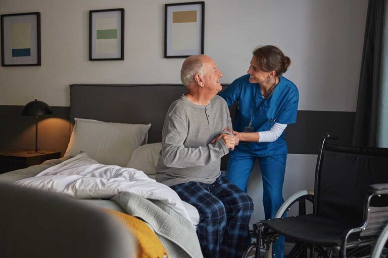 A caregiver assisting an elderly person with organizing daily medication in a comfortable home setting.