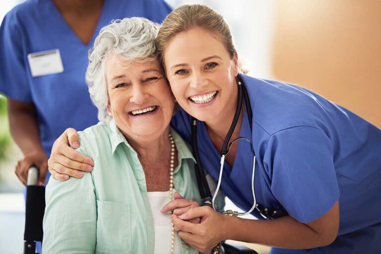 Caregiver and older adult reviewing a notebook together at a kitchen table.